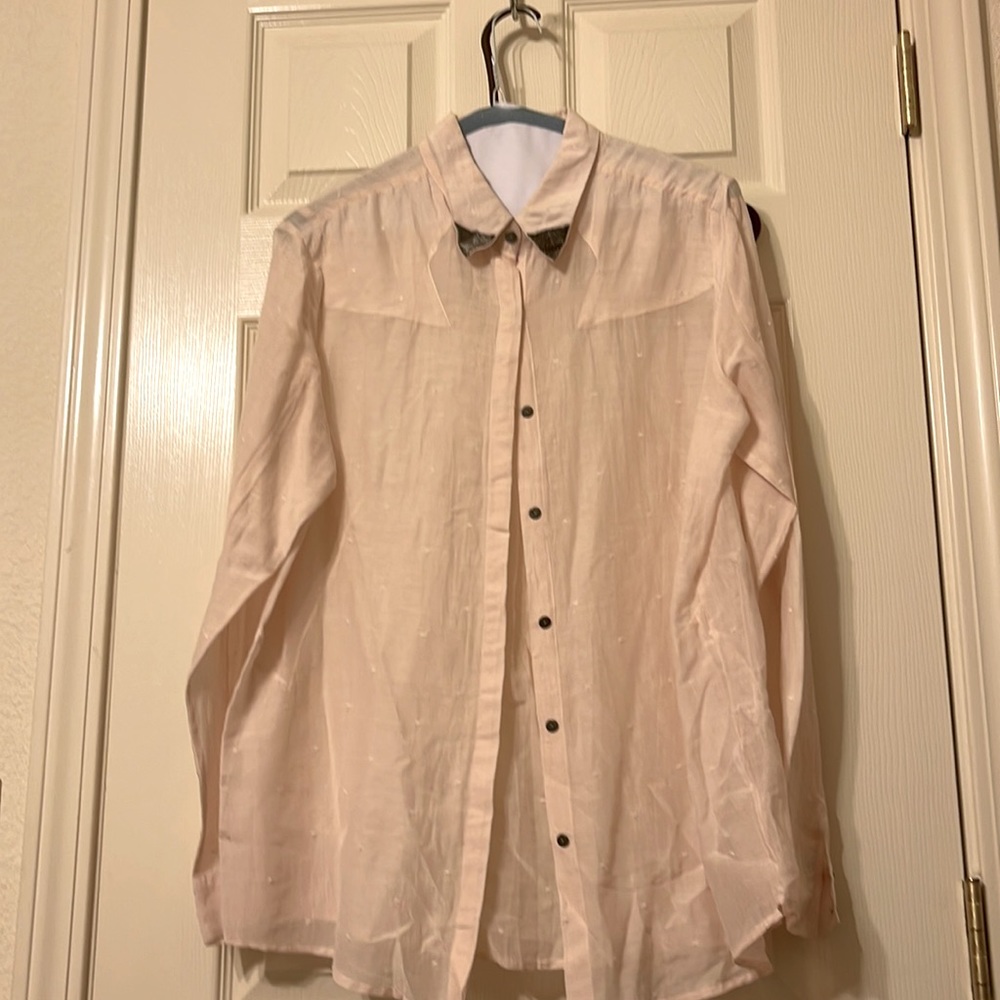 Cute pink top with stitching on collar tips , light and airy cute grey buttons .